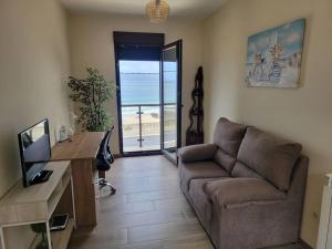 a living room with a couch and a desk at Ventana al Atlantico - House across from the beach in Porto do Son