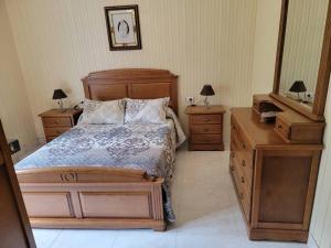 a bedroom with a bed and two dressers and a mirror at Ventana al Atlantico - House across from the beach in Porto do Son