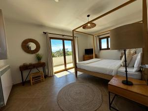 a bedroom with a bed and a large window at Traumhafte Finca am Es Trenc in Ses Covetes
