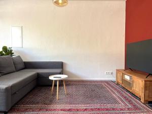 a living room with a couch and a tv at Stilvolle Erdgeschoss-Wohnung: Gemütlich eingerichtet mit eigenem Eingang in Gelsenkirchen
