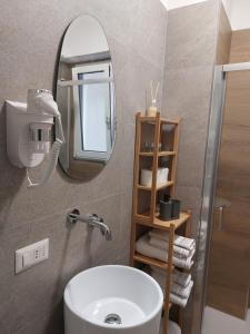 a bathroom with a white sink and a mirror at GiglioApartment Etna Mare in Aci Castello