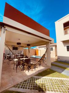 a patio with a hammock and a house at Residencial Floreana Apto Estrela in Salinópolis
