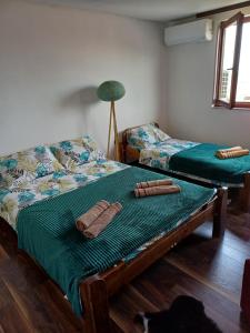 two beds in a room with a green comforter at Himber Rooms in Sarajevo