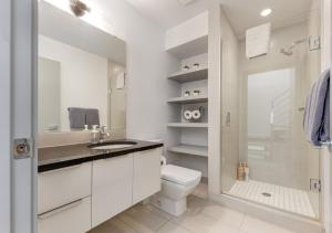 a bathroom with a toilet and a sink and a shower at Newly Renovated Vacation Home w/ Hot Tub & Garage in Calgary +23 photos