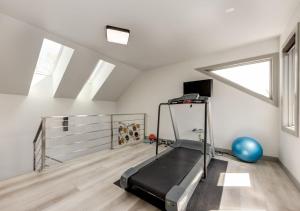 a gym with a treadmill in a room at Newly Renovated Vacation Home w/ Hot Tub & Garage in Calgary