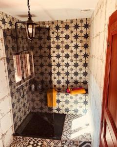 a bathroom with a shower with black and white tiles at La Babayaga in Capestang
