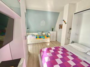 um pequeno quarto com uma cama e um quarto rosa e branco em La Casa di Pamy em Bellaria-Igea Marina