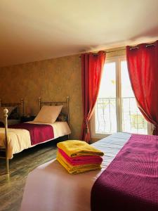 een slaapkamer met 2 bedden en een raam met rode gordijnen bij La Babayaga in Capestang