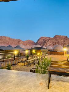 a group of benches and tables in the desert at Faisal Wadi Rum camp in Wadi Rum