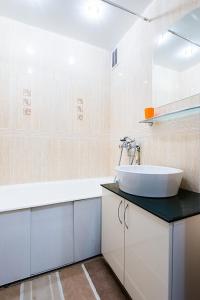 uma casa de banho branca com um lavatório e uma banheira em Studiominsk 15 Apartments em Minsk