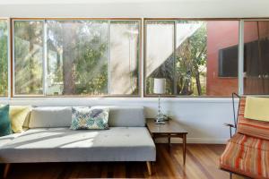 uma sala de estar com um sofá e uma grande janela em Silver Lake Mid-century Nestled In The Treetops em Los Angeles
