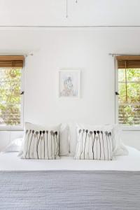Dormitorio blanco con cama blanca y almohadas blancas en Silver Lake Mid-century Nestled In The Treetops en Los Ángeles