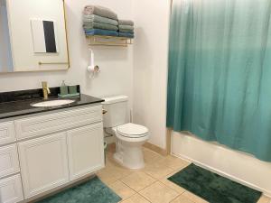 a bathroom with a toilet and a shower curtain at Dog friendly Mid-Century style condo with poolspa in La Quinta