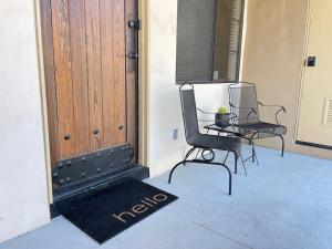 two chairs and a table in front of a door at Dog friendly Mid-Century style condo with poolspa in La Quinta
