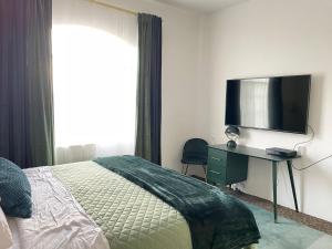 Un dormitorio con una cama y un escritorio con televisión. en Mid Century Styled Condo, Sleeps 4, Pool, Hot Tub, en La Quinta