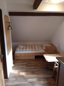 Malá Bystřice的住宿－Penzion U Bušů，一间小卧室,配有一张床和一张桌子
