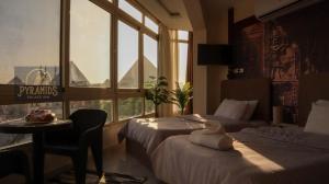 een hotelkamer met 2 bedden en een raam bij Pyramids Palace Inn in Caïro