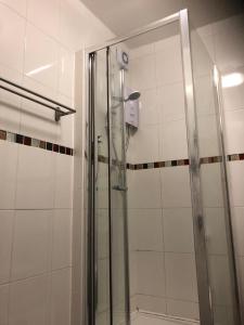 y baño con ducha y puerta de cristal. en Chic and Modern Studio in King's Cross, en Londres