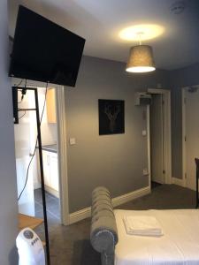 倫敦的住宿－Chic and Modern Studio in King's Cross，一间设有床铺的房间和一台带三脚架的电视