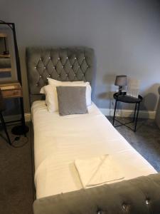 倫敦的住宿－Chic and Modern Studio in King's Cross，一张带银色床头板、白色床单和枕头的床