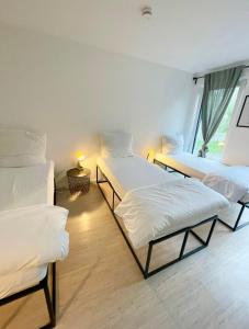 Cette chambre comprend 3 lits et une fenêtre. dans l'établissement Gemütliche Apartments direkt an der Grenze von Hamburg, à Norderstedt
