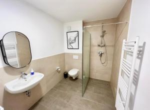 La salle de bains est pourvue d'un lavabo et d'une douche. dans l'établissement Gemütliche Apartments direkt an der Grenze von Hamburg, à Norderstedt