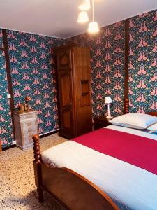 a bedroom with a large bed with floral wallpaper at La Babayaga in Capestang +43 photos
