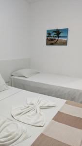 a white bed with a towel on top of it at Pousada Solar da Praia in Tamandaré