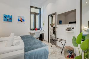een witte slaapkamer met een wit bed en een bureau bij Tango Rooms in Split