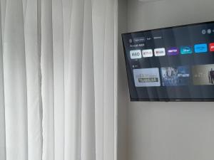 a flat screen tv attached to a white curtain at Route 2 Torrão in Torrão