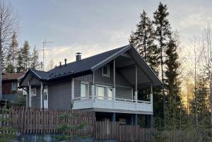 a house with a fence in front of it at Villa IRIS 4, Himos in Jämsä