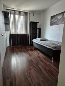 Schlafzimmer mit einem Bett und Holzboden in der Unterkunft Jakan in Stockholm