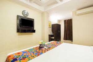 - une chambre avec un lit et une télévision à écran plat dans l'établissement Hotel Golden At Delhi Airport, à New Delhi