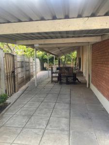 an outdoor patio with awning and a table and chairs at Melrose place in Francistown