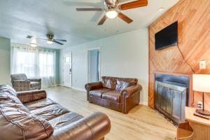 a living room with leather furniture and a fireplace at Centrally Located Gonzales Home with Yard! in Gonzales