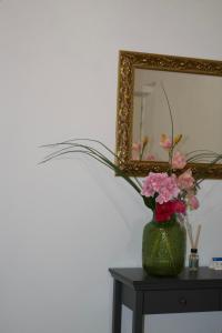 a vase of flowers on a table in front of a mirror at IL CORTILE DELLE ZAGARE in Pollica