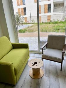 a living room with two chairs and a coffee table at Les Voyages du Loft, entre Eurexpo et St Exupéry in Genas