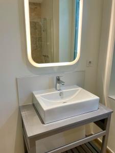 y baño con lavabo blanco y espejo. en Les Voyages du Loft, entre Eurexpo et St Exupéry, en Genas