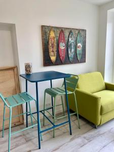 une table bleue, deux chaises et un canapé dans l'établissement Les Voyages du Loft, entre Eurexpo et St Exupéry, à Genas