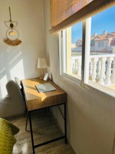biurko z laptopem obok okna w obiekcie Bungalow Aguas Nuevas Costa del Cezar w mieście Torrevieja