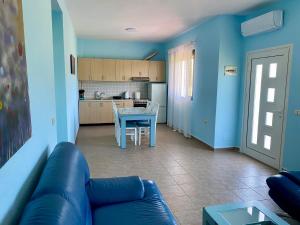 ein Wohnzimmer und eine Küche mit einem Sofa und einem Tisch in der Unterkunft White & Blue Apartment's in Golem
