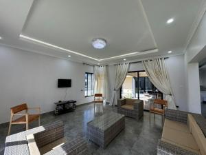 uma sala de estar com sofás e uma televisão de ecrã plano em Eleganciana Lodges Limited em Lusaka