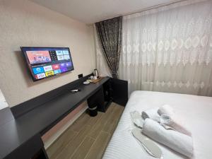 a hotel room with a bed and a flat screen tv at Feycem Suites&Hotel in Istanbul