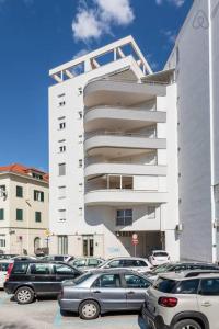 un estacionamiento con autos estacionados frente a un edificio en Apartments Nena, en Split