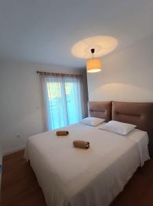 ein Schlafzimmer mit einem weißen Bett mit zwei Handtüchern darauf in der Unterkunft Luxury apartment Povlja in Povlja + 32 Fotos