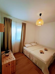 1 Schlafzimmer mit 2 Betten, einer Lampe und einem Fenster in der Unterkunft Luxury apartment Povlja in Povlja