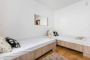 2 camas en una habitación con paredes blancas en Apartments Nena, en Split