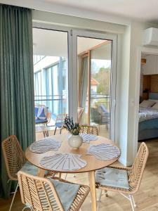 einen Esstisch mit Stühlen und einen Balkon in der Unterkunft Miła Odmiana - Enklawa Krynica Morska in Krynica Morska