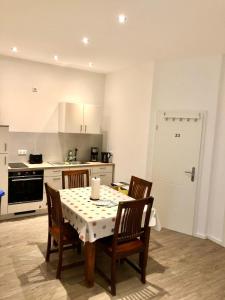 a kitchen with a table with four chairs and a kitchen with a stove at Vilstal Apartments in Reisbach