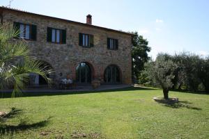 una grande casa in mattoni con un albero nel cortile di Casa Felice a Lucignano